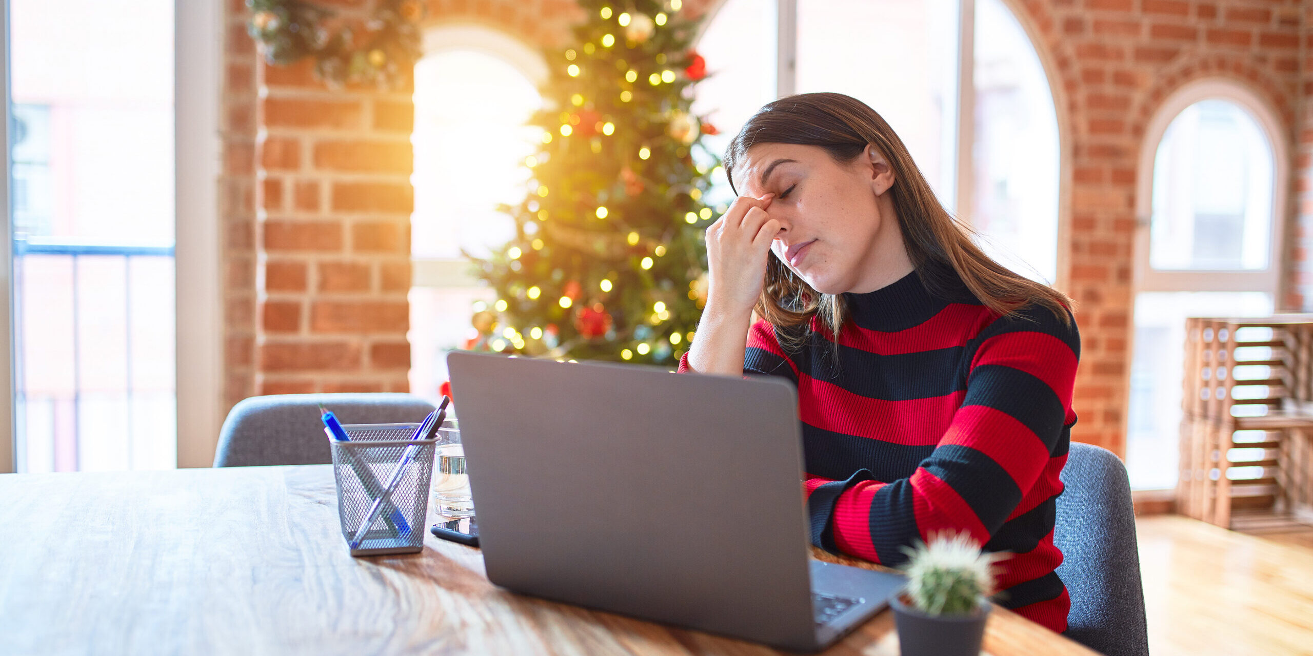 Beautiful woman sitting at the table working with laptop at home Stress