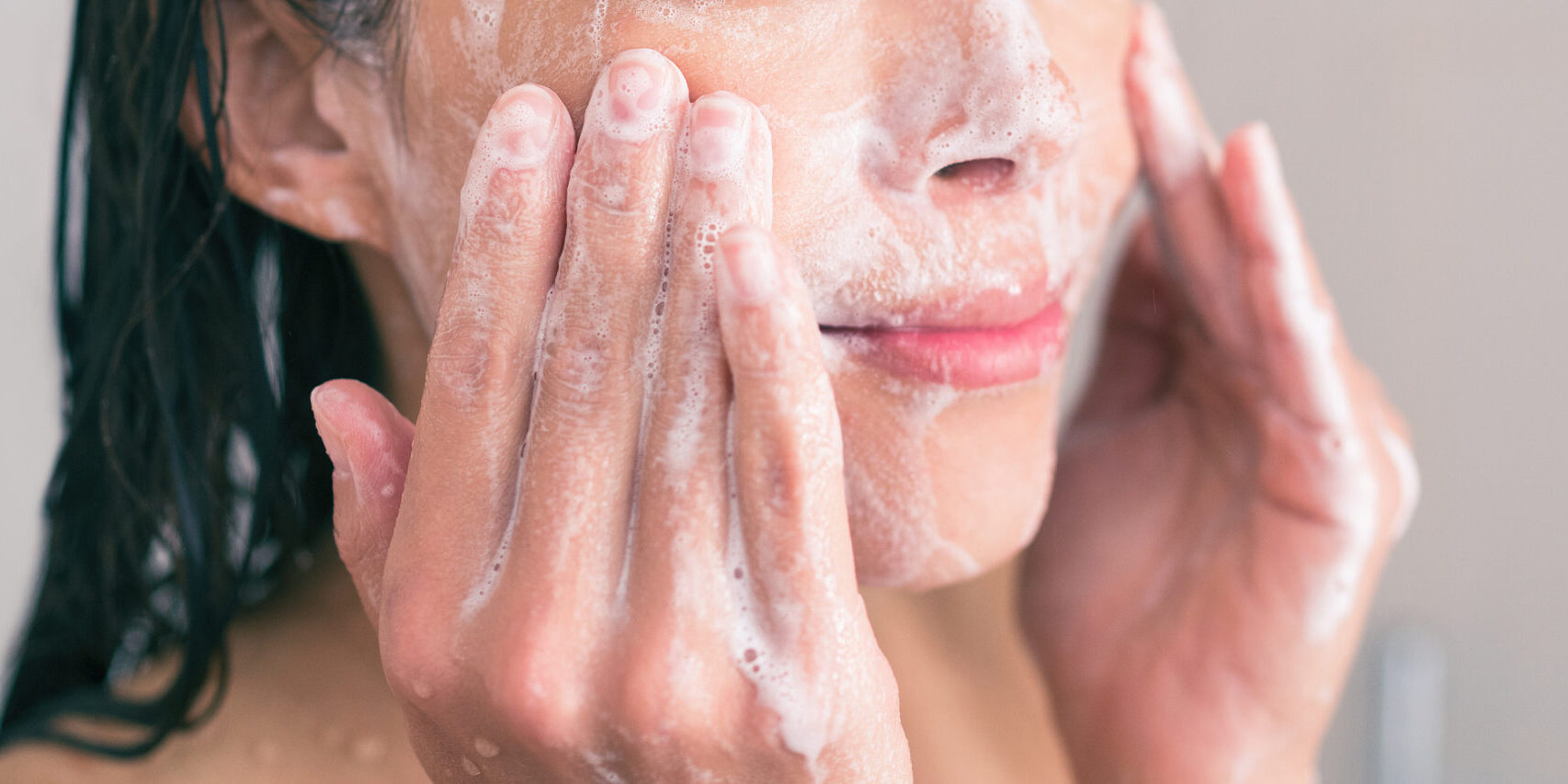 woman washing her face with a cleanser