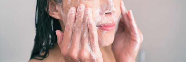woman washing her face with a cleanser