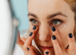 Woman using eye cream on under eye bags and dark circles.