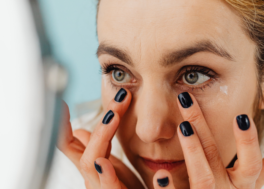 Woman using eye cream on under eye bags and dark circles.